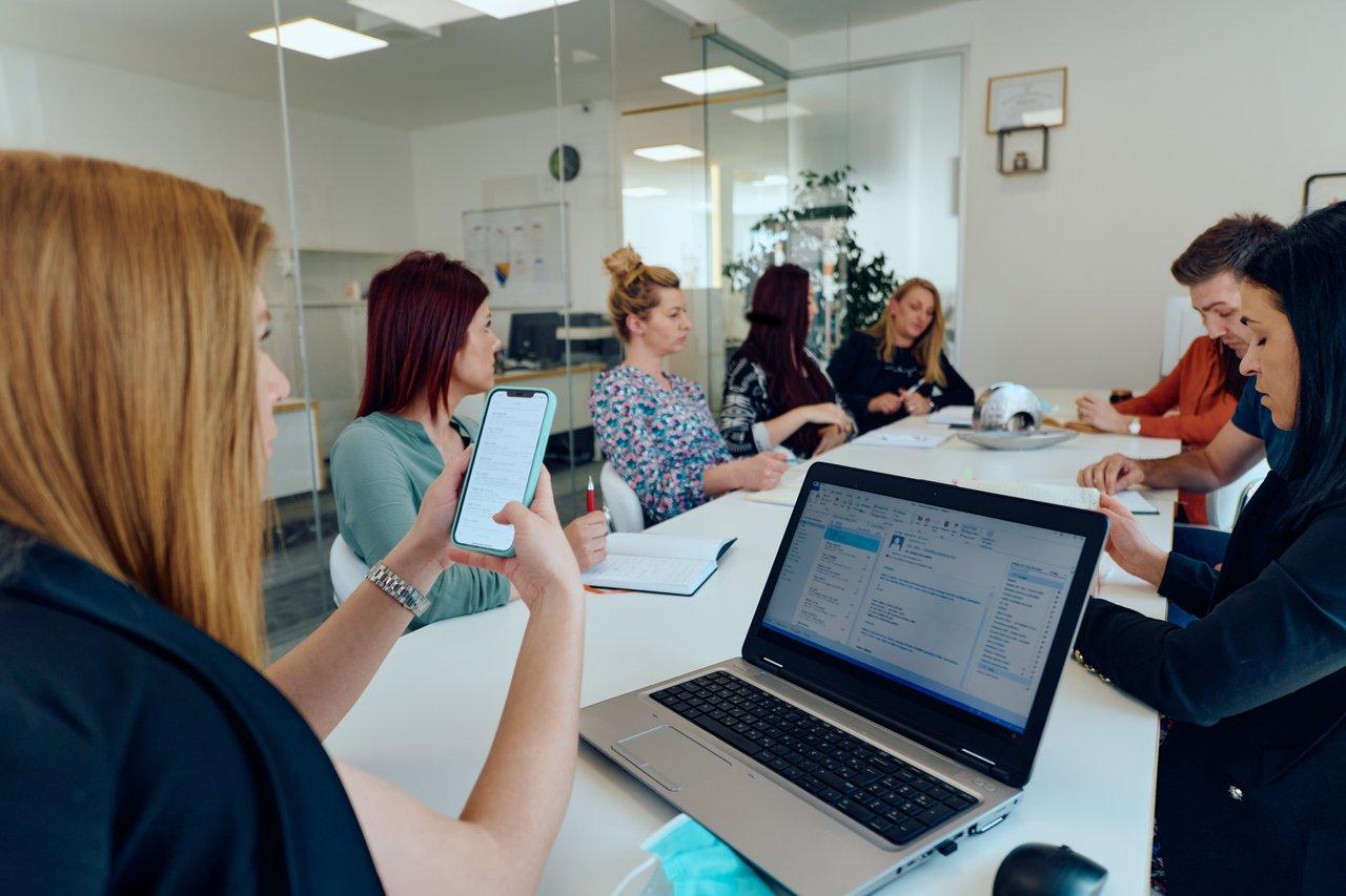 Réunion d'une équipe diverse de professionnels en consultant desk dans un bureau moderne.